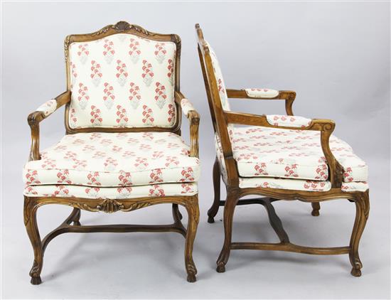 A pair of French carved walnut floral striped upholstered fauteuils, H. 3ft 2in.